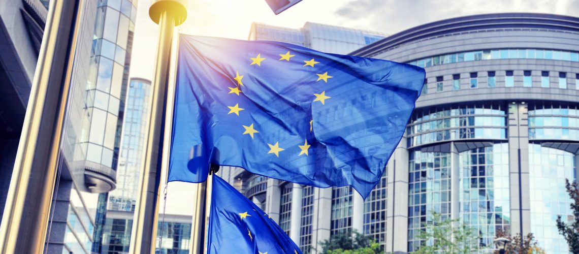 EU flags waving in front of European Parliament building. Brussels, Belgium